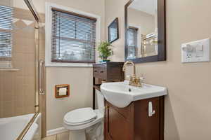 Bathroom with vanity and shower / bath combination with glass door