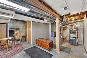 Unfinished basement featuring strapped water heater and heating unit