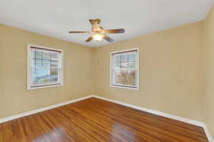 Unfurnished room featuring hardwood / wood-style flooring and a ceiling fan