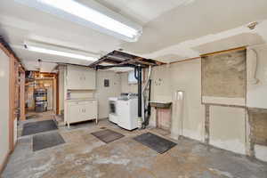 Unfinished below grade area with water heater and independent washer and dryer