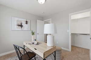 Home office featuring light colored carpet and baseboards