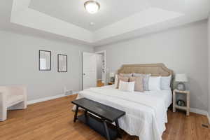 Bedroom featuring a raised ceiling and wood finished floors