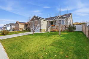 Single story home featuring concrete driveway, a garage, and stone siding