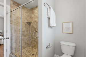 Bathroom featuring a shower stall and toilet