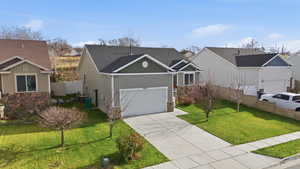 View of front of home with stone siding, driveway, a garage, and board and batten siding