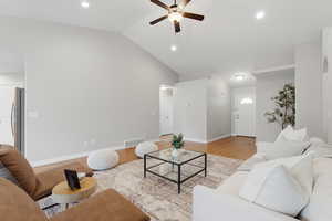 Living area with ceiling fan, vaulted ceiling, light wood-style flooring, and recessed lighting