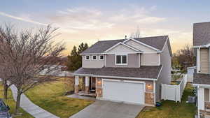View of front of home featuring a shingled roof, a garage, driveway, and a porch