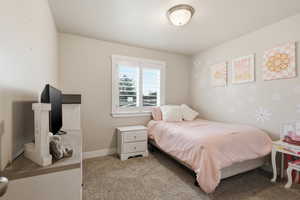 Bedroom featuring light carpet and baseboards
