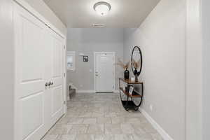 Foyer featuring stairs and a textured ceiling