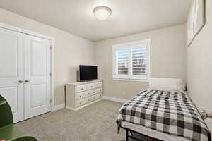 Bedroom featuring light carpet and a closet