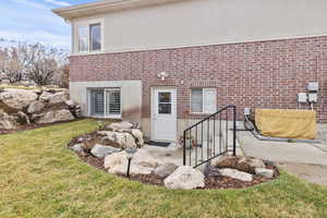 Outside basement entrance to home with rock landscape
