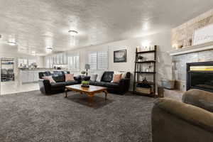 Family room featuring a textured ceiling, a fireplace, and carpet