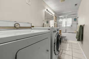 Laundry area/bathroom featuring washer/clothes dryer, light tile floors