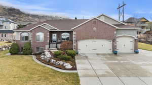 View of front of home with a front yard, an attached oversized garage, concrete driveway, and brick siding