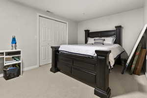 Bedroom with light carpet and a large closet