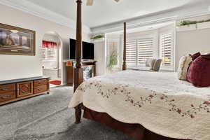 Primary bedroom with carpet flooring, a ceiling fan, multiple windows, connected bathroom, and ceiling rim lighting