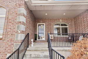 Home front entrance featuring a glass storm door and covered porch