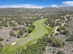 Bird's eye view of a golf course and a mountain backdrop