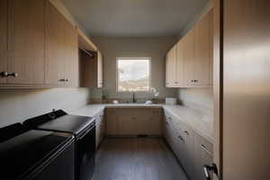 Laundry room featuring cabinet space, washing machine and clothes dryer, and dark wood-style flooring
