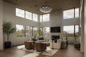 Living area featuring wood finished floors, a high wood ceiling, a fireplace, and hanging lights