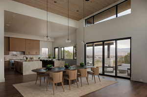 Dining area with dark wood finished floors, a mountain view, and a high wood ceiling