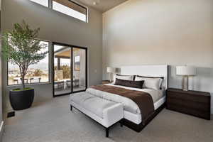 Bedroom with multiple windows, access to outside, carpet floors, a high ceiling, and a mountain view