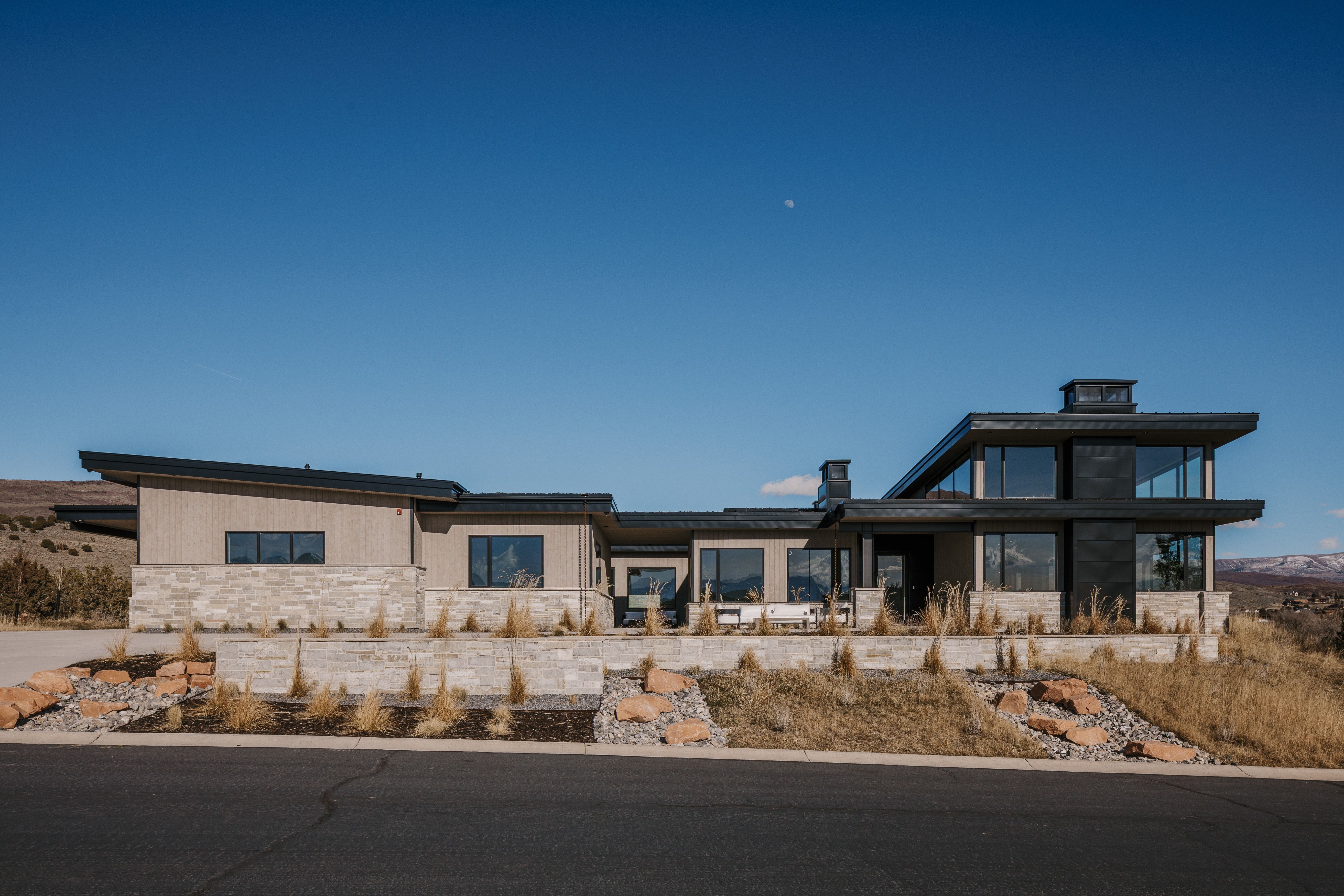 View of front facade with stone siding and a sunroom