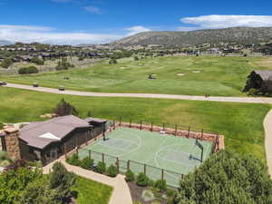 Aerial perspective of suburban area featuring a mountainous background and a golf club