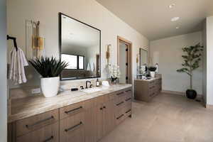 Full bathroom with two vanities, recessed lighting, and light tile patterned floors