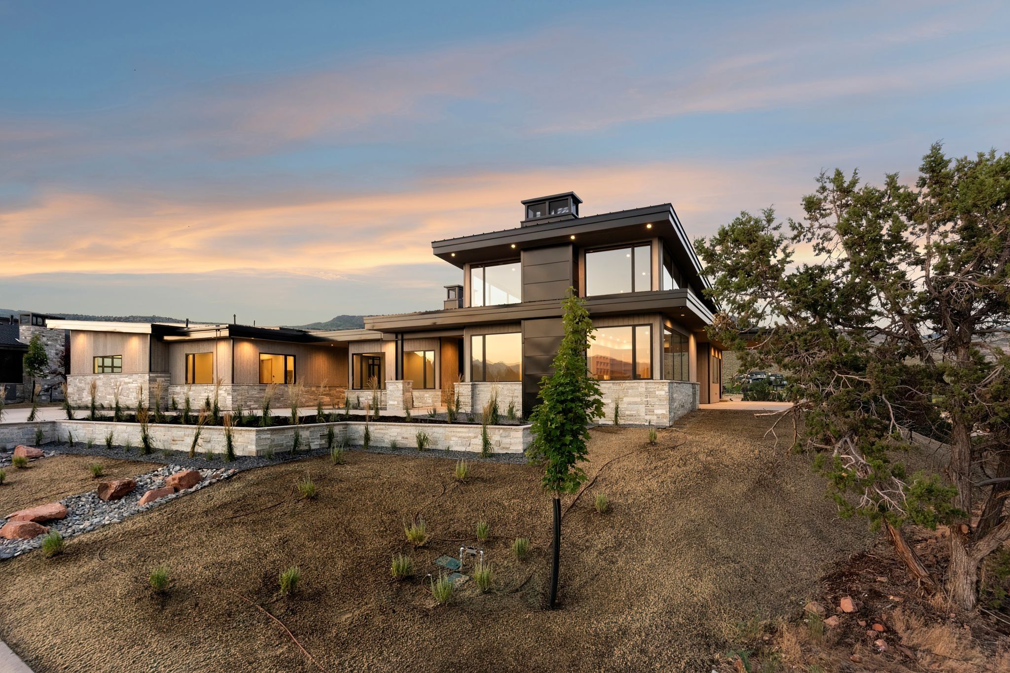 View of front of home with stone siding and a patio
