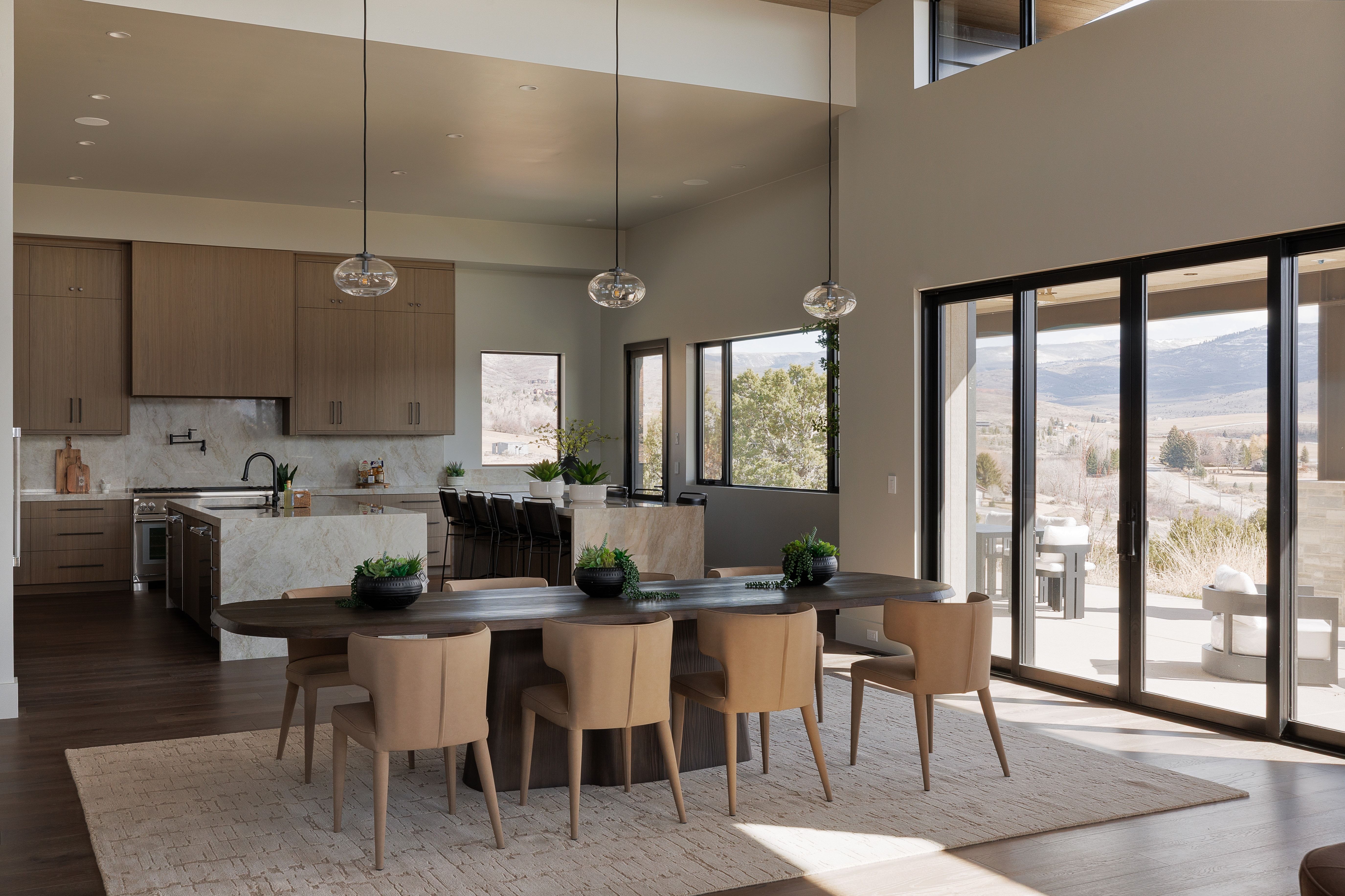 Kitchen with a mountain view, dark wood-style flooring, modern cabinets, pendant lighting, and a high ceiling