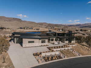 View of front of house with solar panels, a mountain view, an attached garage, and a desert view