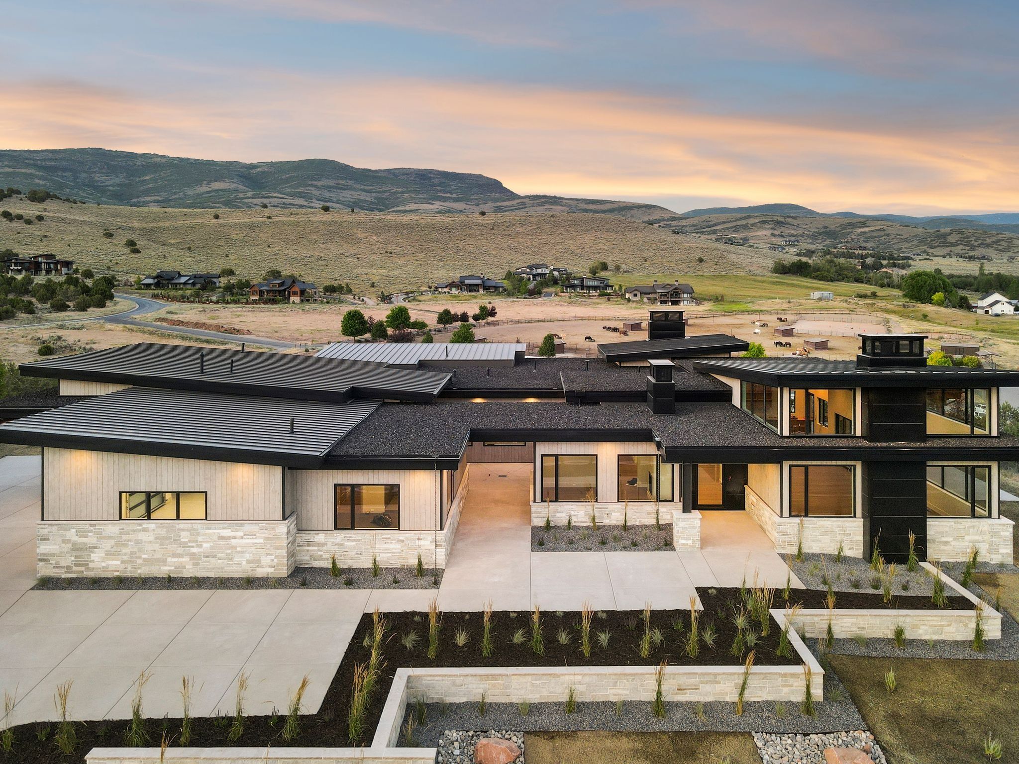 View of front of home featuring stone siding, a mountain view, and a patio area