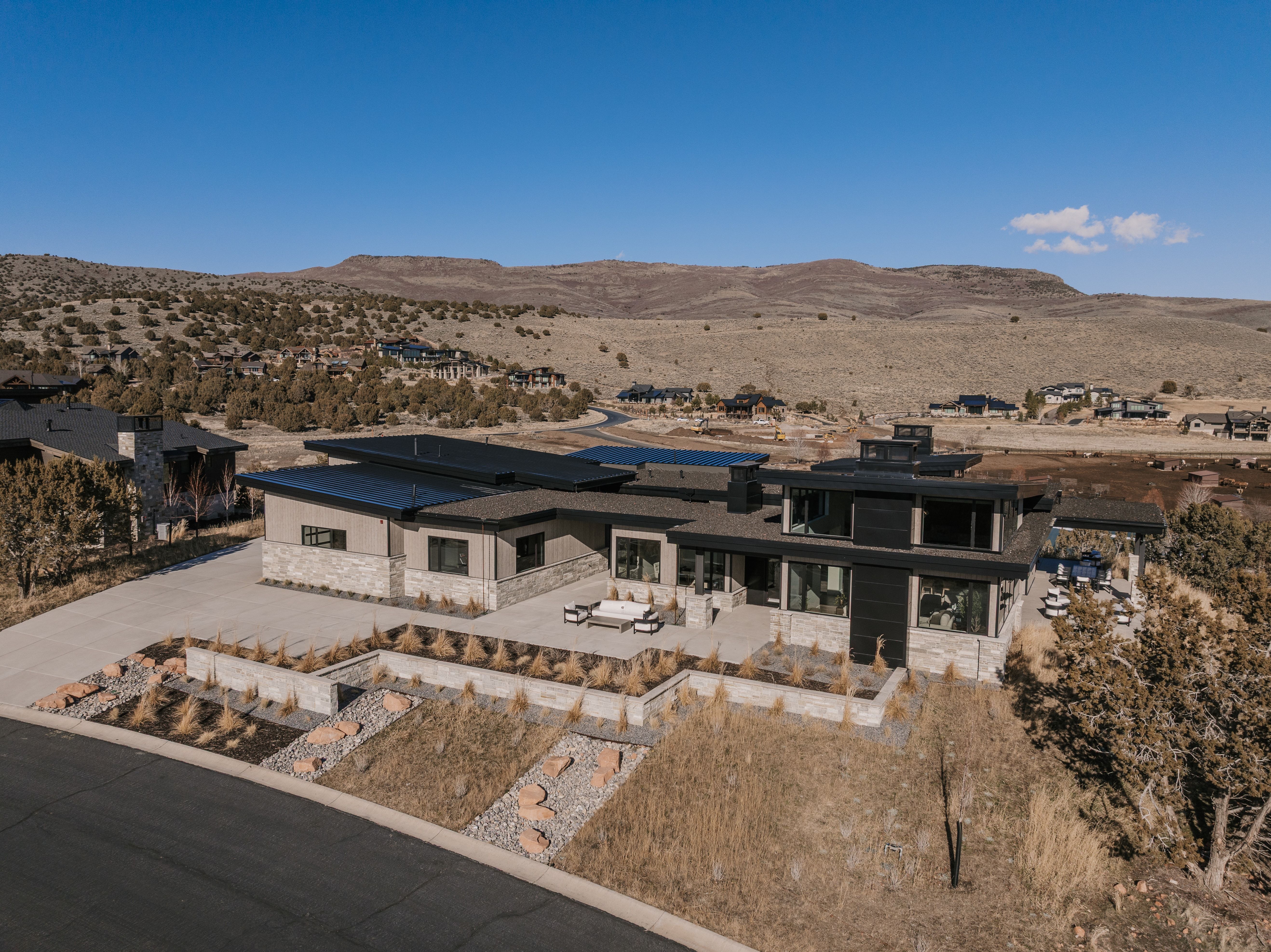 View of front of house with a patio area, a mountain view, solar panels, a chimney, and view of desert