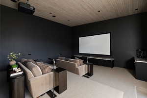 Home theater room featuring light colored carpet and wooden ceiling