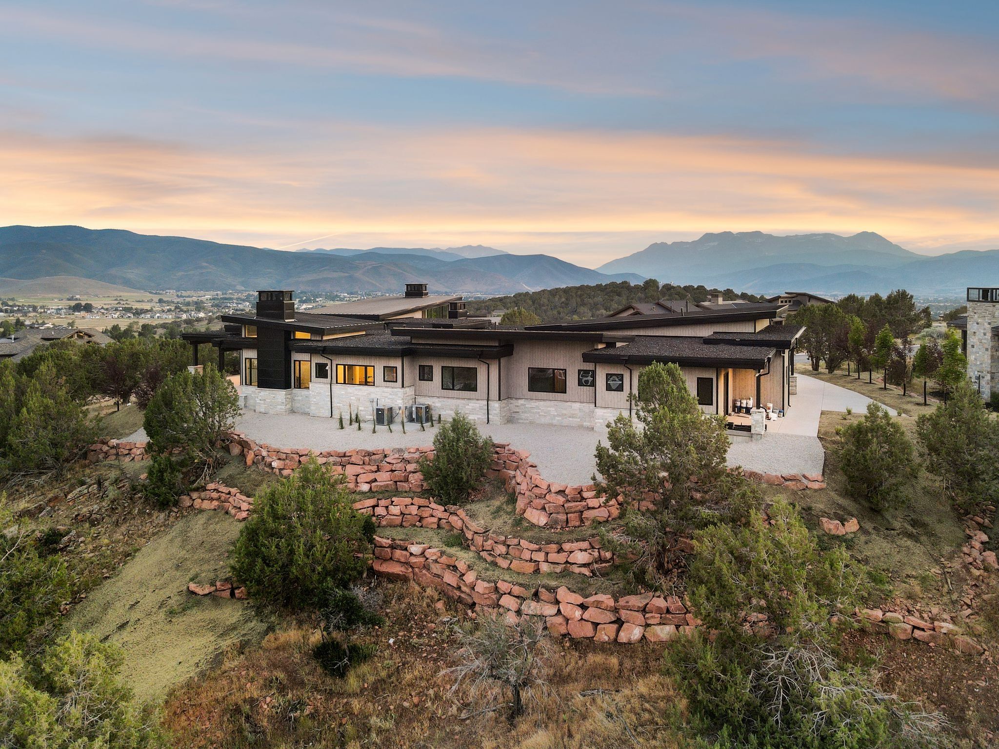 Back of property at dusk with a patio area, a mountain view, and a chimney