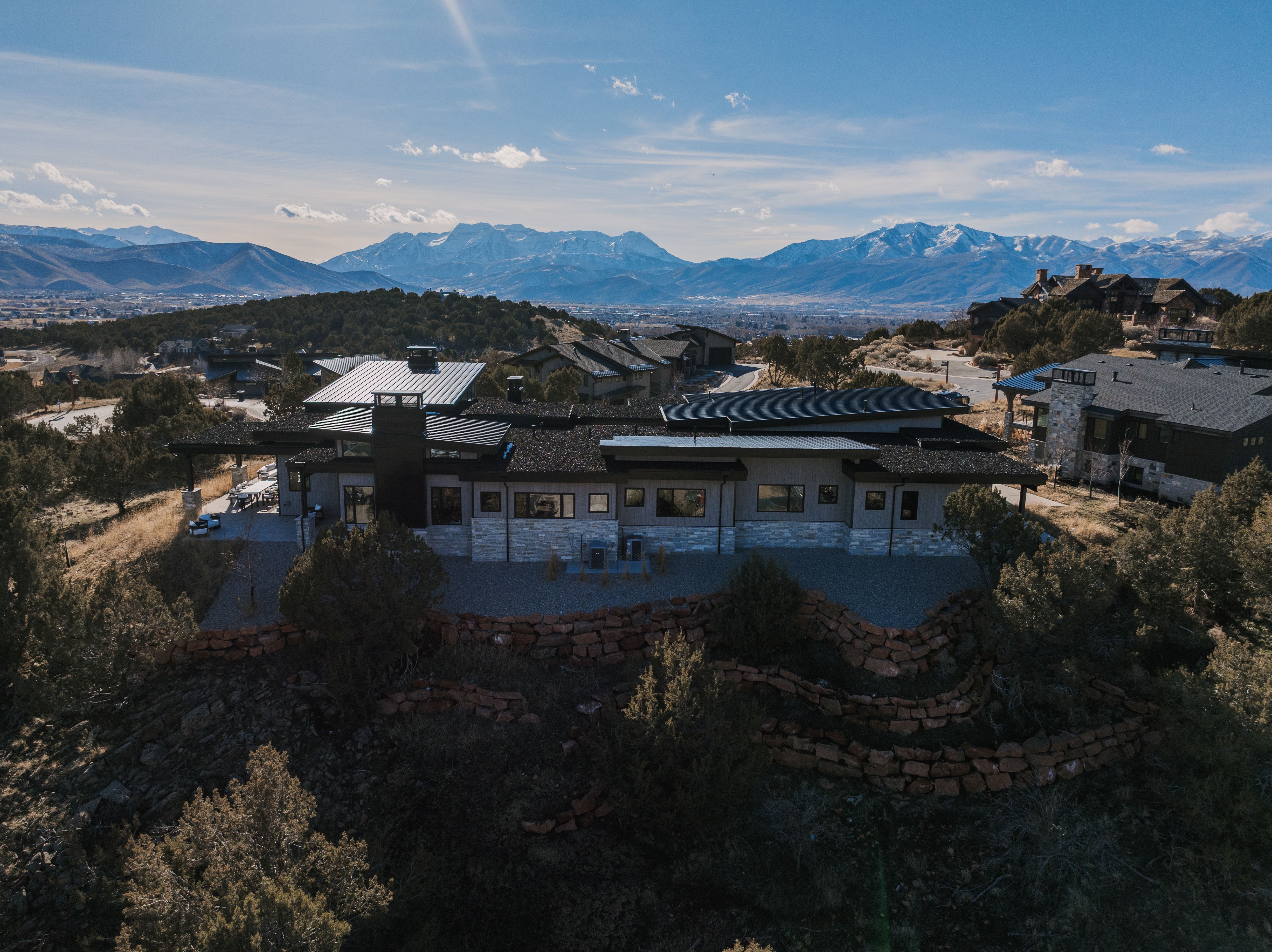 Back of house featuring a patio, a mountain view, and stone siding