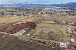 Aerial view of property and surrounding area with rural landscape, a mountainous background, and property boundaries highlighted
