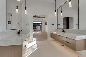 Full bathroom with two vanities, ceiling fan, a high ceiling, and light tile patterned flooring