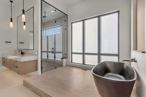 Bathroom featuring a stall shower, vanity, and a freestanding bath