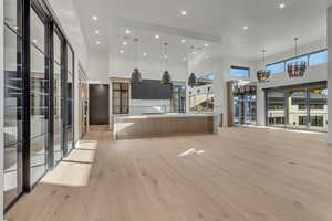 Kitchen featuring modern cabinets, a high ceiling, open floor plan, a spacious island, and suspended lighting