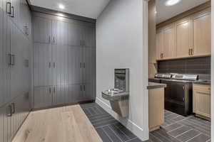 Laundry area featuring wood finish floors, cabinet space, and separate washer and dryer
