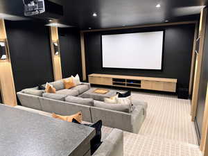Cinema with light colored carpet and recessed lighting
