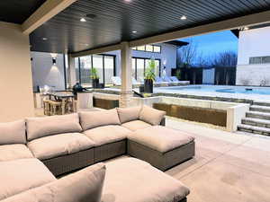 View of patio with an outdoor kitchen, an outdoor lounge area with bar, and an outdoor pool