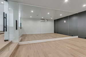 Empty room with light wood finished floors and recessed lighting