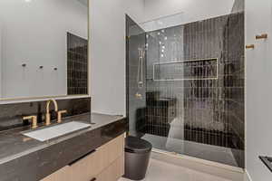 Bathroom featuring vanity, a walk in shower, and light tile patterned flooring