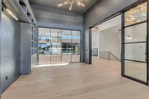 Unfurnished room with light wood-style floors and hanging lights