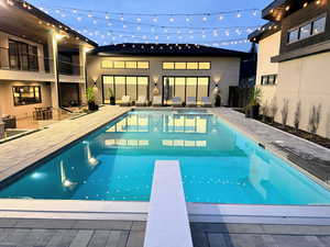 Swimming pool with a patio area, a diving board, and a balcony
