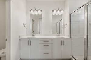 Bathroom with double vanity and a stall shower