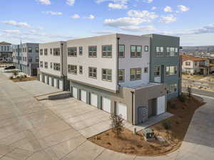 View of property with a garage, driveway, and a residential view